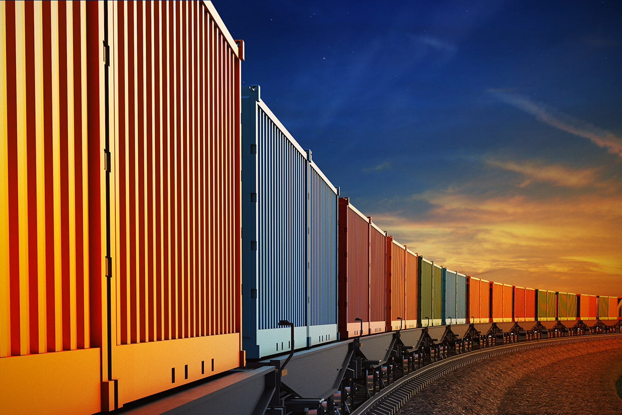 Image of a freight train with multicolored cars at sunset