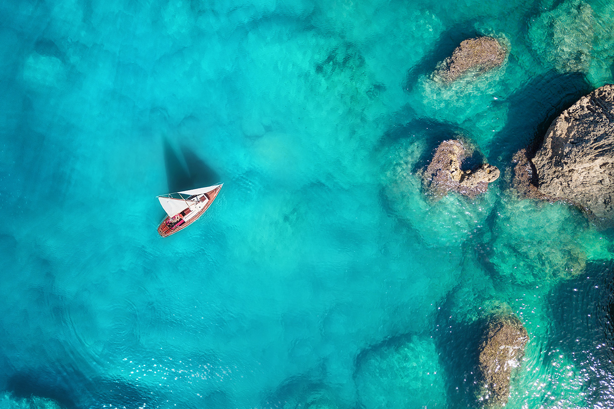 Birds eye view of ocean with sailboat